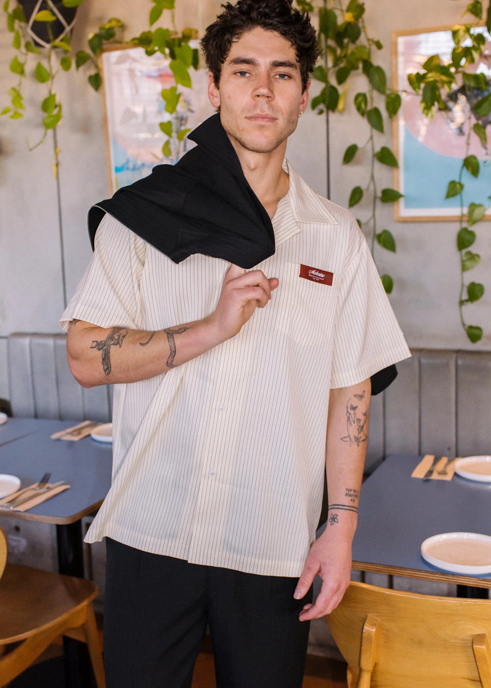 Person wearing a white shirt with a logo in a restaurant setting