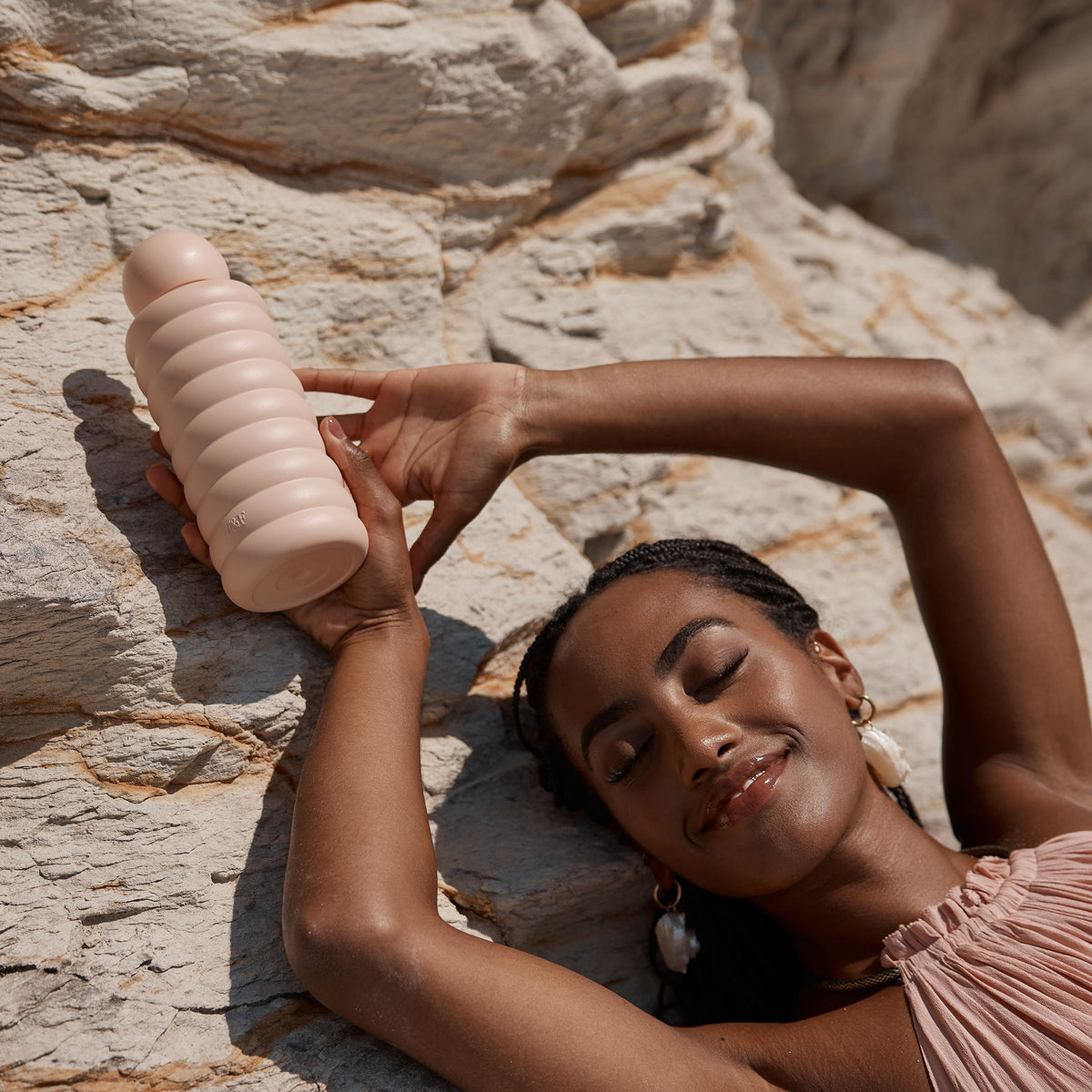 Fox & Fallow Bubble Bottle in Blush, held up on the rocks